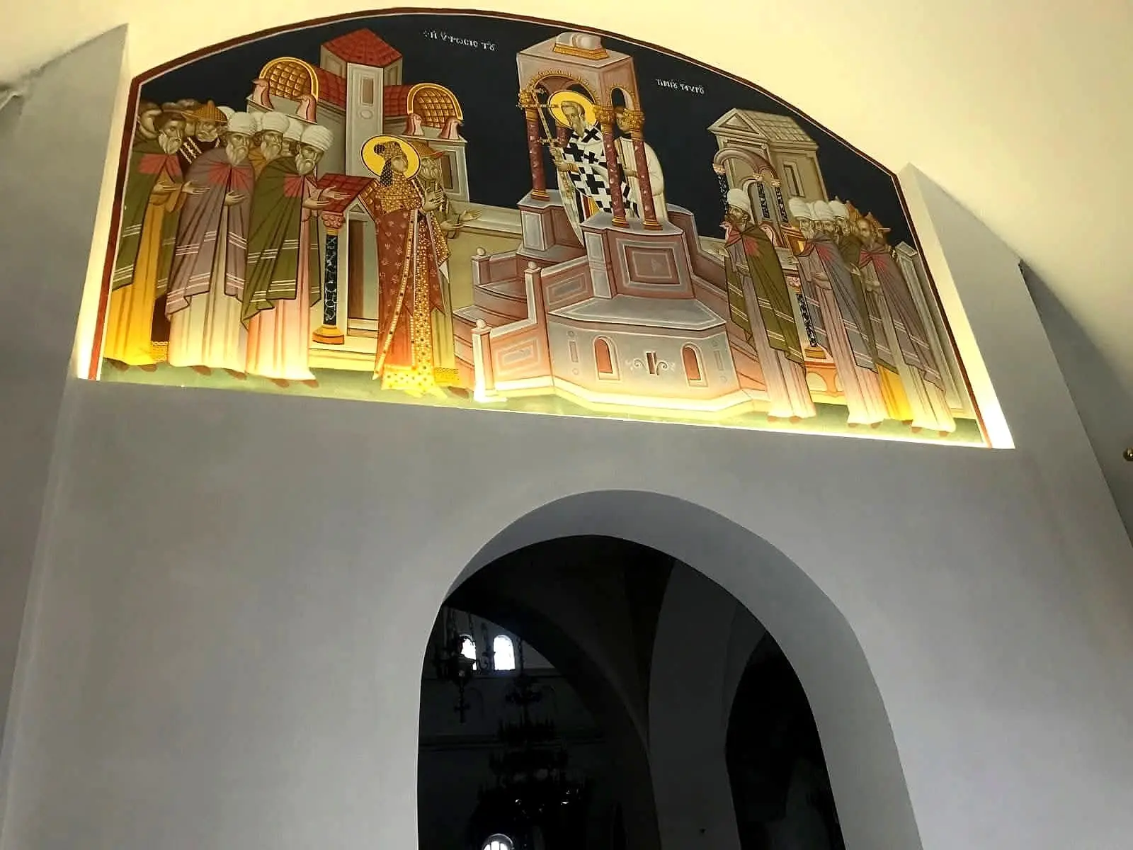 Τοξωτό άνοιγμα από γυψοσανίδα σε ναό, με φωτισμένη αγιογραφία από πάνω